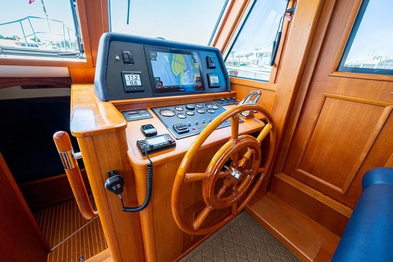 First Light Yacht Photos Pics Helm of 2007 Grand Banks 47 Classic yacht with wooden steering wheel and navigation controls.