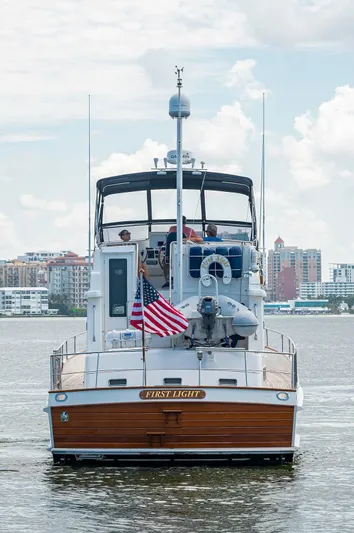 First Light Yacht Photos Pics 2007 Grand Banks 47 Classic yacht on water with cityscape background.