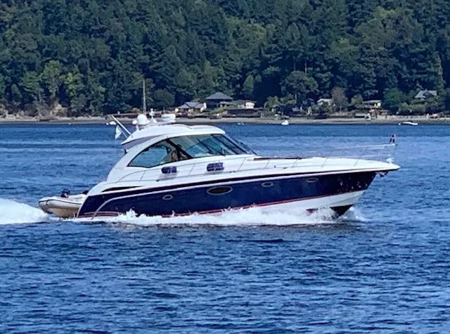 Bella Blue Yacht Photos Pics 2010 Formula 45 yacht cruising on a scenic lake with forested shoreline.