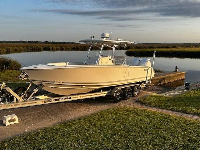  Yacht Photos Pics 2013 Jupiter 30 FS boat on trailer by a serene lake at sunset.