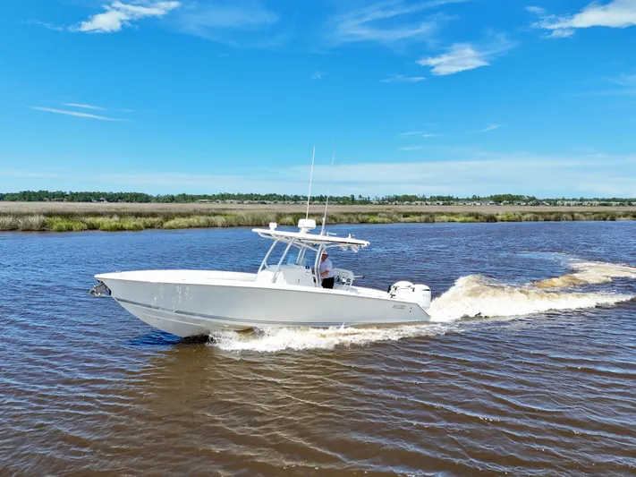  Yacht Photos Pics 2013 Jupiter 30 FS boat cruising on a sunny day, with clear blue skies.