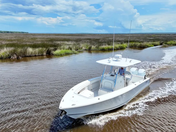  Yacht Photos Pics 2013 Jupiter 30 FS boat cruising through marshland under a blue sky.