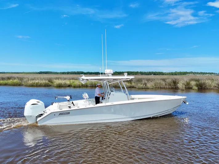  Yacht Photos Pics 2013 Jupiter 30 FS boat cruising on a calm river under a clear blue sky.