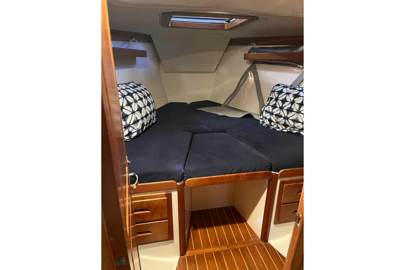 Thumper Yacht Photos Pics Cozy cabin interior of 2001 Tartan 3700 Sloop with plush bedding and wooden accents.