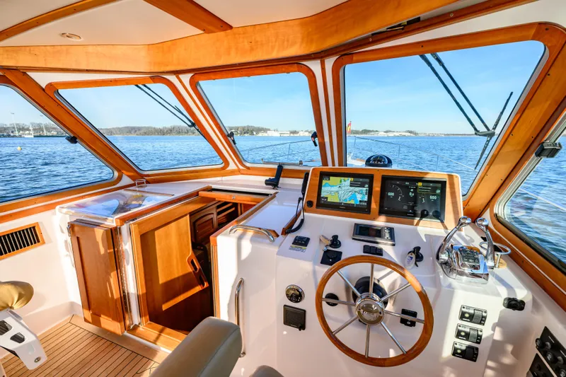 More Mojo Yacht Photos Pics 2009 Sabre 42 Hard Top Express helm with navigation screens and wooden accents on open water.