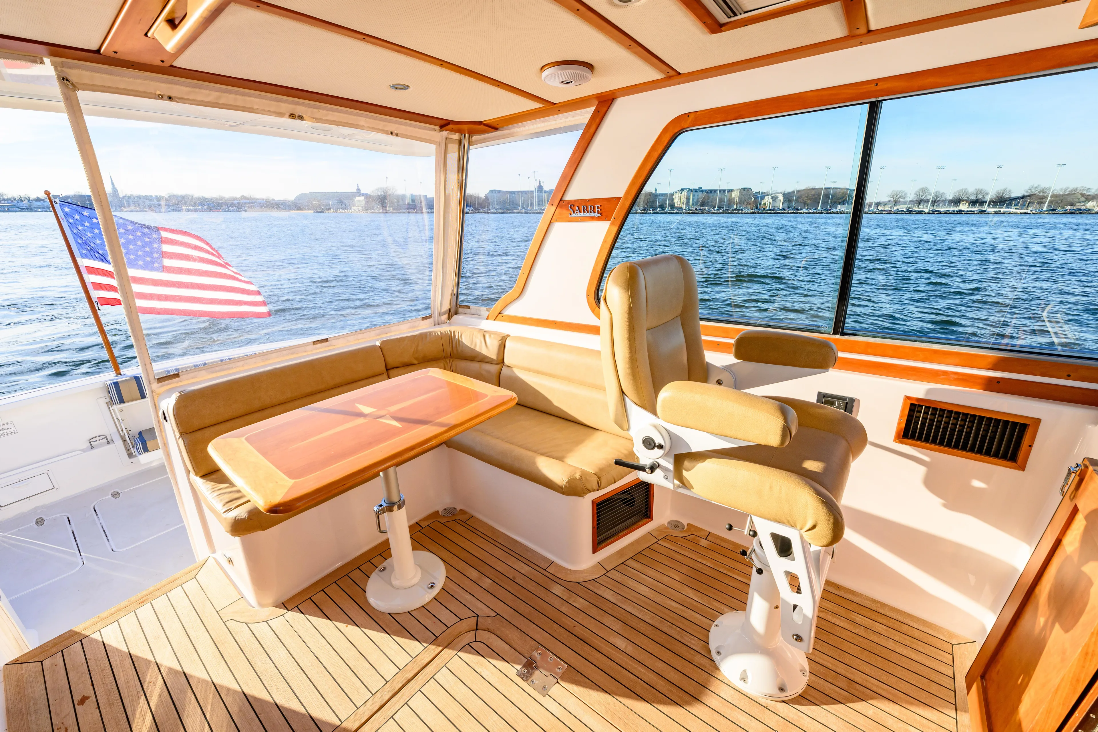 More Mojo Yacht Photos Pics Interior of 2009 Sabre 42 Hard Top Express yacht with seating and table, overlooking water.