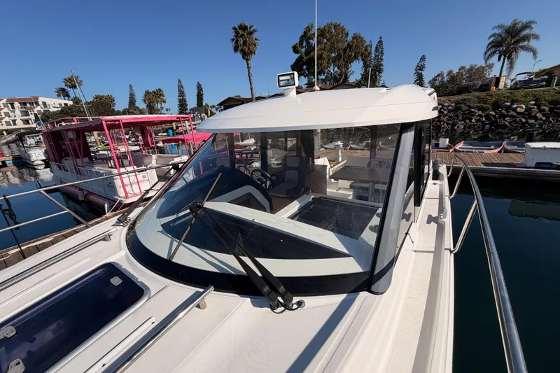  Yacht Photos Pics 2020 Jeanneau NC 895 boat docked in a marina under clear blue skies.