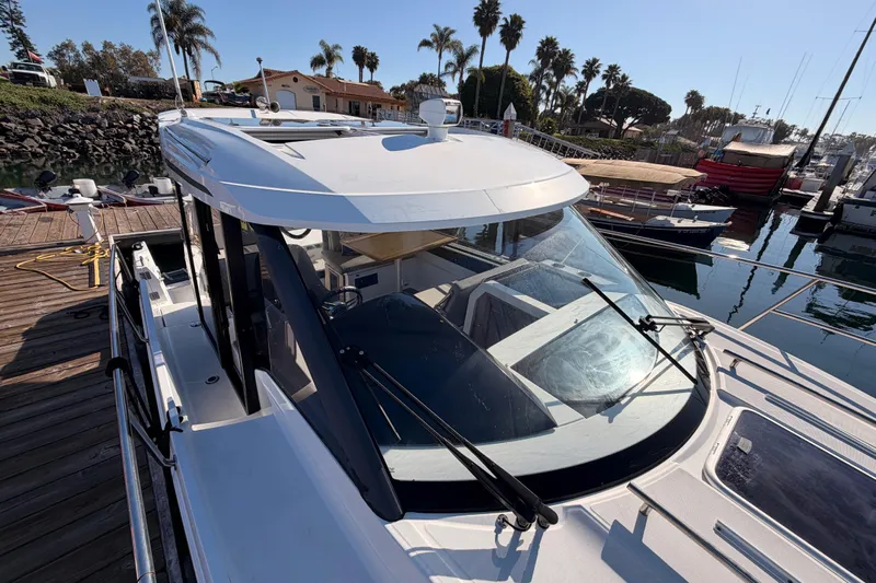  Yacht Photos Pics 2020 Jeanneau NC 895 docked at marina, showcasing sleek design and spacious cabin.