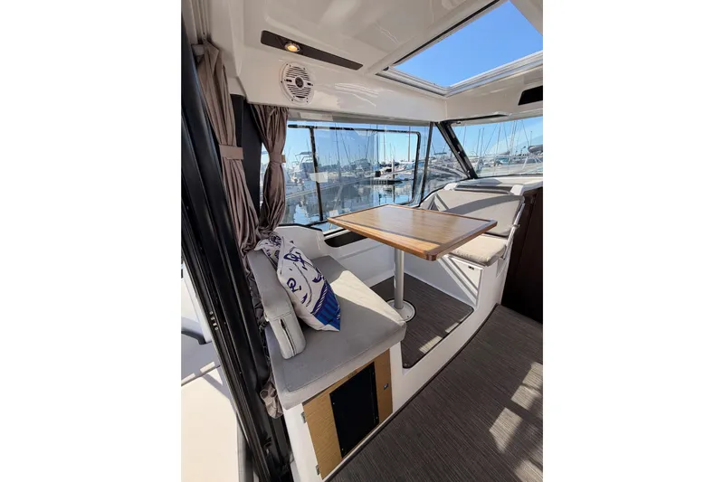  Yacht Photos Pics Interior of 2020 Jeanneau NC 895 boat with seating and table, marina view.
