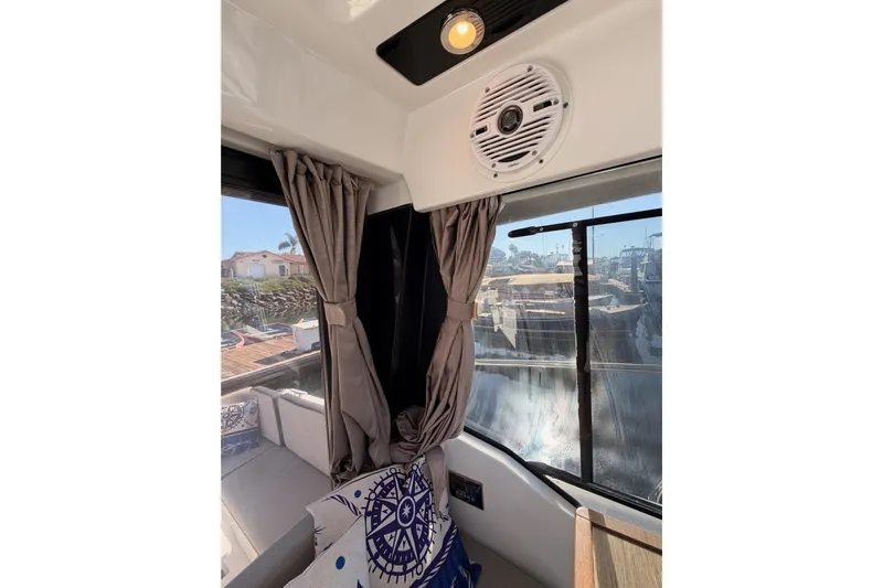  Yacht Photos Pics Interior of 2020 Jeanneau NC 895 boat with curtains and nautical-themed decor.