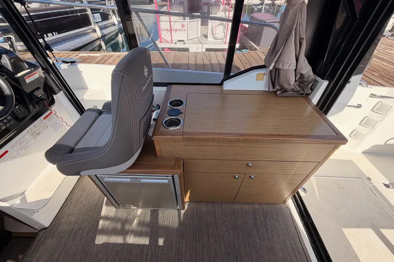  Yacht Photos Pics 2020 Jeanneau NC 895 interior with helm seat and wooden cabinetry.