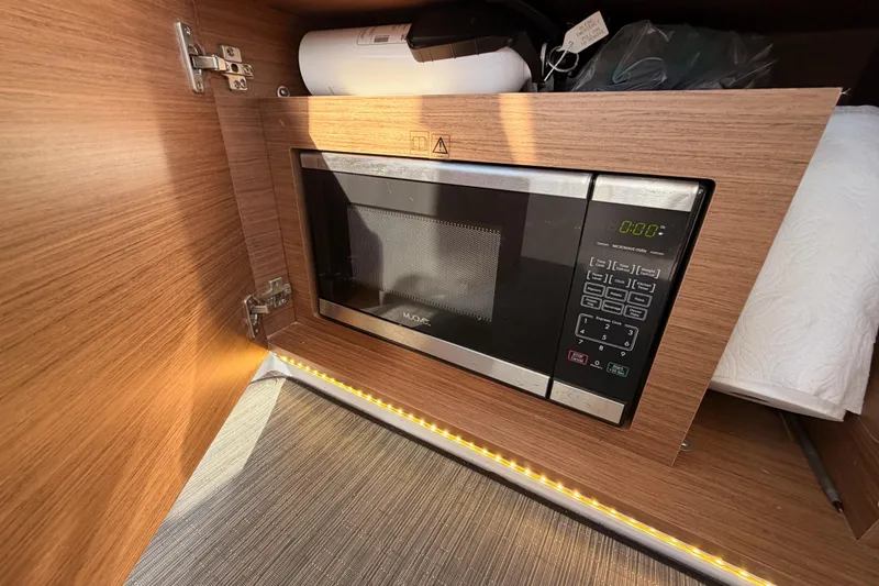  Yacht Photos Pics Built-in microwave in Jeanneau NC 895 boat, 2020 model, with wood cabinetry.