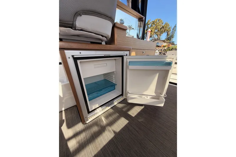  Yacht Photos Pics Open refrigerator inside 2020 Jeanneau NC 895 boat, showcasing interior storage space.