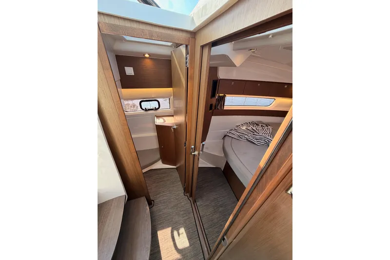  Yacht Photos Pics 2020 Jeanneau NC 895 interior cabin with cozy bed and modern wood finish.