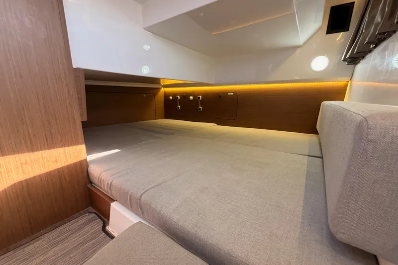  Yacht Photos Pics 2020 Jeanneau NC 895 cabin interior with cozy bed and ambient lighting.