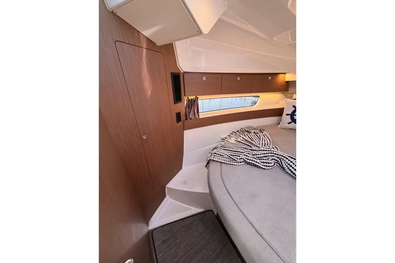  Yacht Photos Pics 2020 Jeanneau NC 895 cabin interior with cozy bed and wooden accents.