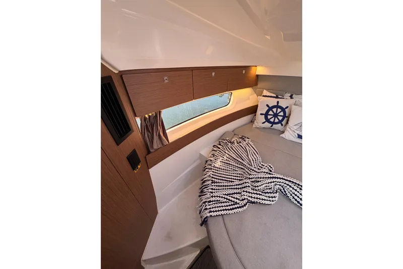  Yacht Photos Pics 2020 Jeanneau NC 895 cabin interior with cozy bedding and nautical decor.