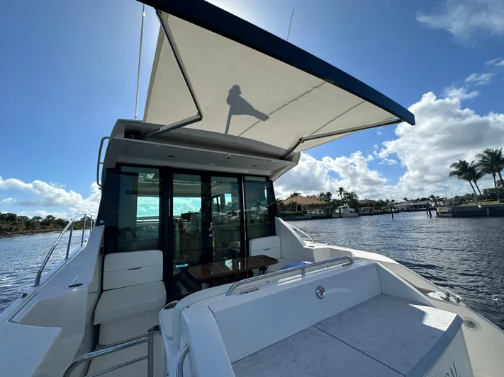 Aeronautical Yacht Photos Pics 2022 Tiara Yachts C39 Coupe with sunshade, docked by a scenic waterfront.
