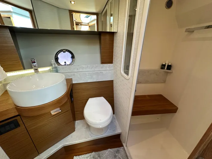 Aeronautical Yacht Photos Pics Luxurious bathroom in 2022 Tiara Yachts C39 Coupe with modern fixtures and wood accents.