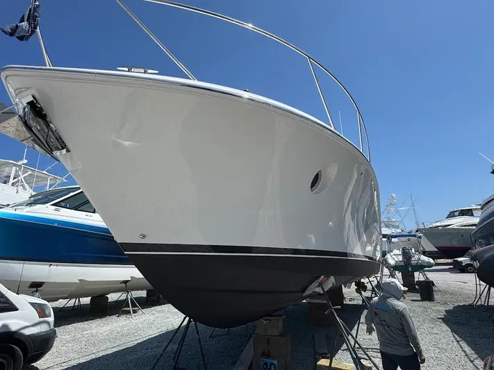 Aeronautical Yacht Photos Pics 2022 Tiara Yachts C39 Coupe on dry dock, side view under clear blue sky.