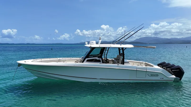  Yacht Photos Pics 2020 Boston Whaler 380 Outrage boat on clear blue water, under a sunny sky.