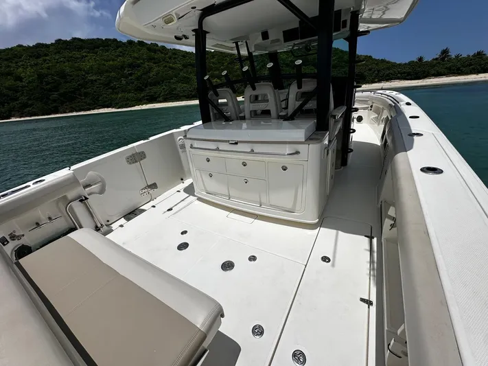  Yacht Photos Pics 2020 Boston Whaler 380 Outrage boat interior with seating, ocean backdrop, and lush green island.