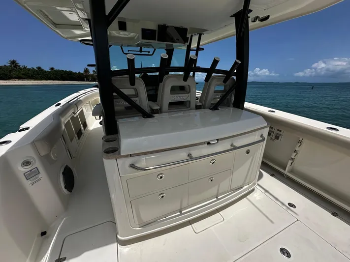  Yacht Photos Pics 2020 Boston Whaler 380 Outrage boat interior with seating and storage, near tropical shoreline.