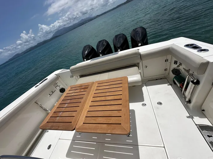  Yacht Photos Pics Boston Whaler 380 Outrage 2020 boat deck with wooden table and ocean view.