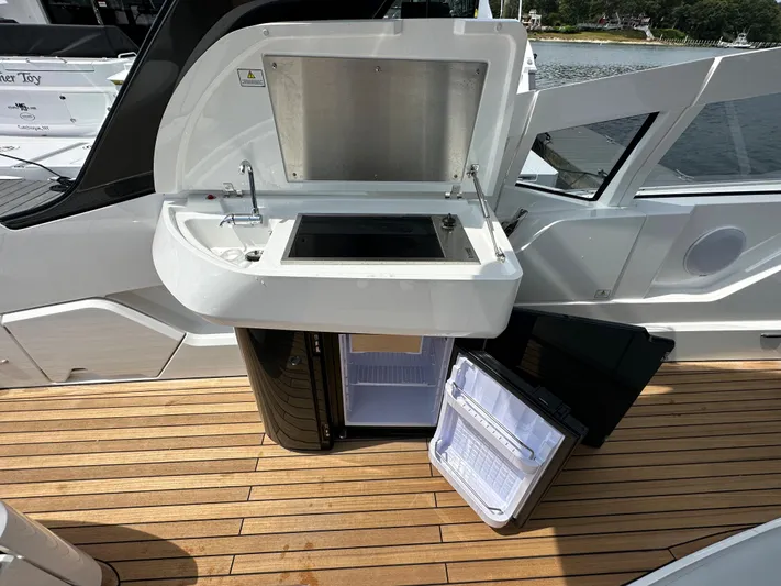 '23 Fairline Fline 33 Ob Yacht Photos Pics 2023 Fairline F//Line 33 Outboard yacht with open kitchenette and mini-fridge on deck.