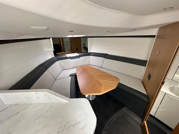 '23 Fairline Fline 33 Ob Yacht Photos Pics Interior of 2023 Fairline F//Line 33 Outboard with modern seating and wooden table.