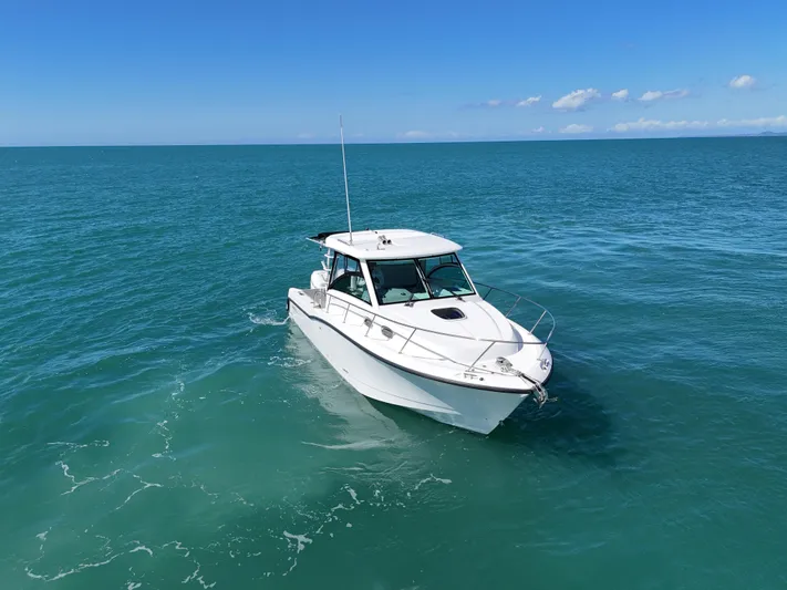  Yacht Photos Pics 2015 Boston Whaler 315 Conquest boat cruising on open sea under clear blue sky.