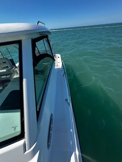  Yacht Photos Pics 2015 Boston Whaler 315 Conquest cruising on open water, side view.