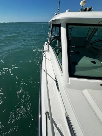  Yacht Photos Pics 2015 Boston Whaler 315 Conquest cruising on open water, side view.