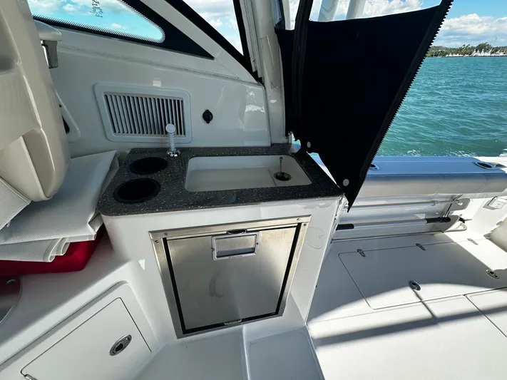 Yacht Photos Pics 2015 Boston Whaler 315 Conquest boat interior with sink and storage, overlooking the ocean.