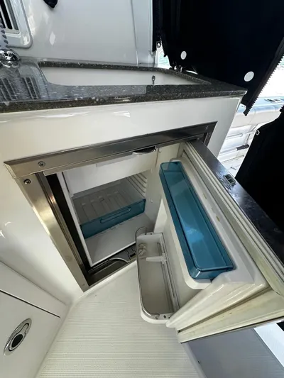  Yacht Photos Pics 2015 Boston Whaler 315 Conquest interior with open mini fridge and countertop.