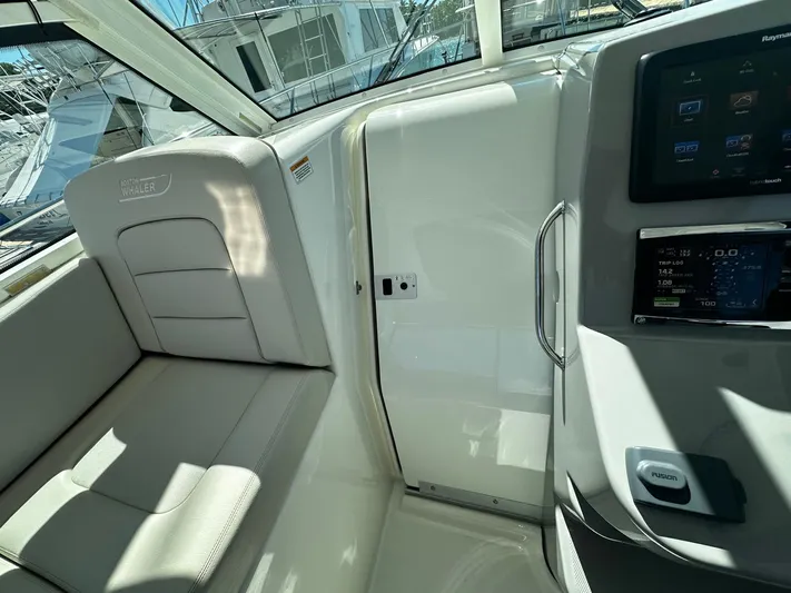  Yacht Photos Pics Interior view of a 2015 Boston Whaler 315 Conquest boat, featuring seating and control panel.