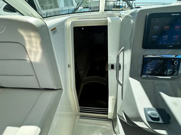  Yacht Photos Pics 2015 Boston Whaler 315 Conquest cabin entrance with modern dashboard and seating.