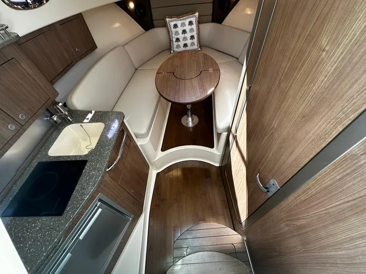  Yacht Photos Pics 2015 Boston Whaler 315 Conquest cabin interior with kitchenette and seating area.