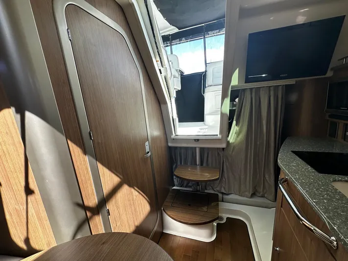  Yacht Photos Pics Interior of 2015 Boston Whaler 315 Conquest boat, featuring wooden cabinetry and modern amenities.