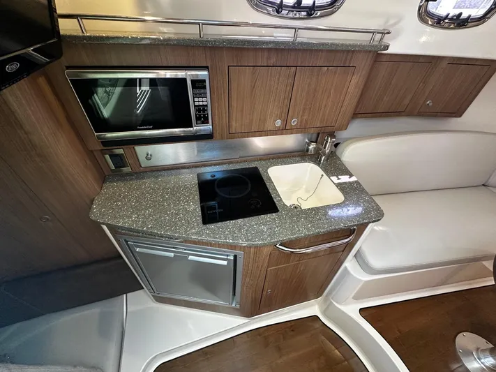  Yacht Photos Pics 2015 Boston Whaler 315 Conquest interior kitchen with microwave, sink, and stove.