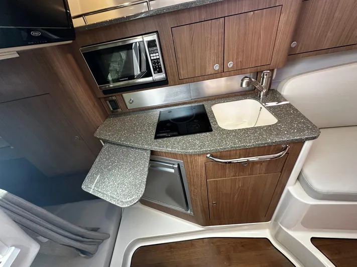  Yacht Photos Pics 2015 Boston Whaler 315 Conquest interior kitchen with sink, stove, and microwave.