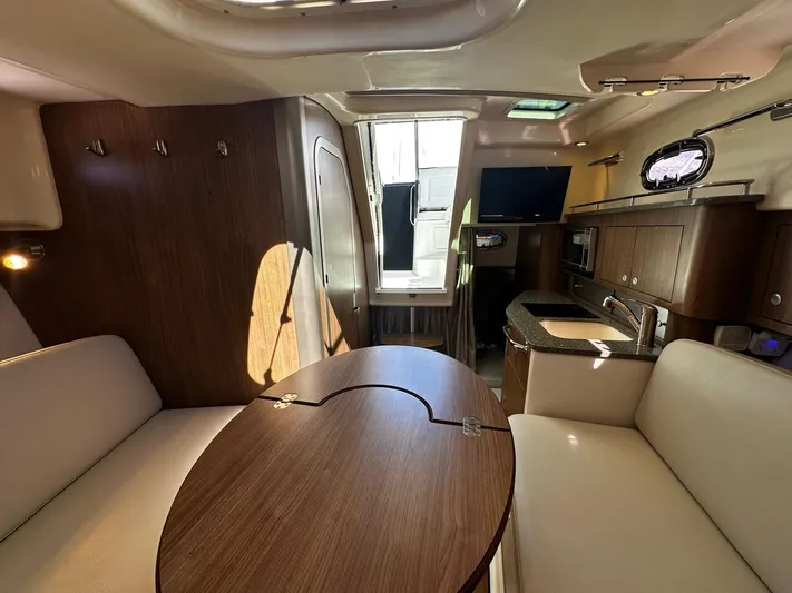  Yacht Photos Pics Interior of 2015 Boston Whaler 315 Conquest, featuring a cozy dining area and kitchenette.