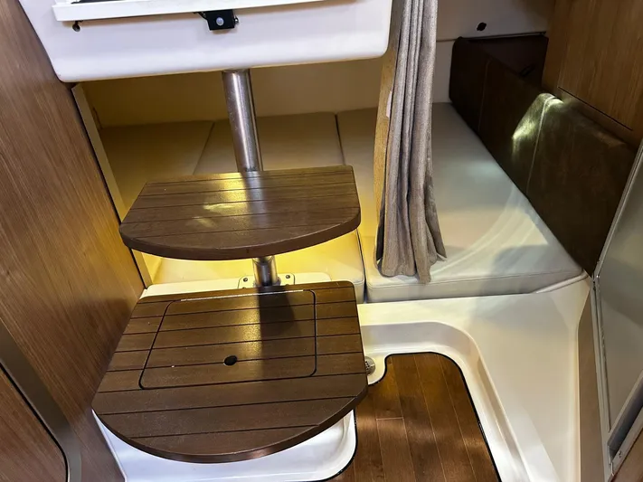  Yacht Photos Pics Interior of 2015 Boston Whaler 315 Conquest, featuring wooden steps and cozy cabin space.