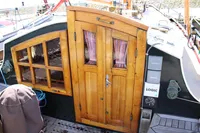 Wooden cabin door and window on a 1987 Zeeschouw Liamer sailboat deck.