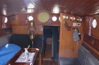 Interior of 1987 Zeeschouw Liamer boat, featuring wooden paneling, cozy seating, and nautical decor.
