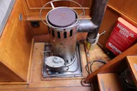 Vintage 1987 Zeeschouw Liamer stove with fire extinguisher in wooden cabin interior.