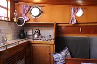 Interior of 1987 Zeeschouw Liamer boat with cozy kitchen and seating area.