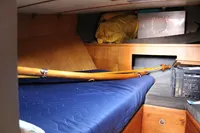 Interior cabin of 1987 Zeeschouw Liamer sailboat with blue bedding and wooden accents.
