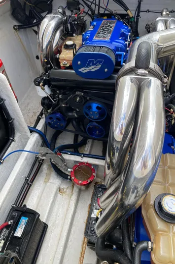 Wheeler Dealer Yacht Photos Pics Engine of a 2006 Fountain 42 Executioner boat with blue and chrome components.