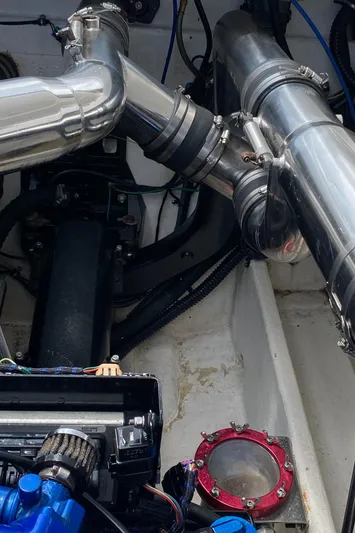 Wheeler Dealer Yacht Photos Pics Engine components of a 2006 Fountain 42 Executioner boat, featuring metallic pipes and mechanical parts.